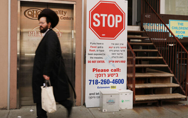 A sign warns people of measles symptoms in the Orthodox Jewish community in Williamsburg, Brooklyn in 2019. (Spencer Platt/Getty Images via JTA)