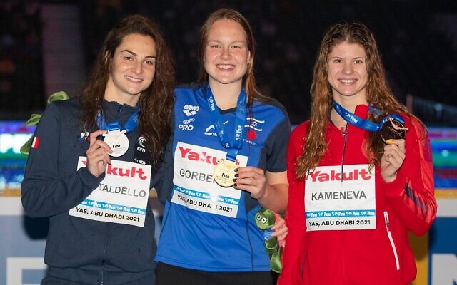 Israel's Anastasia Gorbenko poses with her gold medal -- alongside France's silver medalist Brill Gastaldello (left) and Russia's Maria Kamaneva, the bronze medalist -- after winning the 100-meter individual medley on December 19, 2021, at the World Swimming Championships in Abu Dhabi. It was Gorbenko's second gold at the championships (Israel Swimming Association)