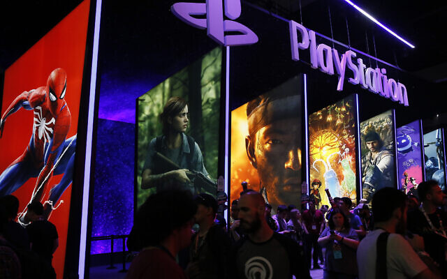People stand online next to the PlayStation booth at the 24th Electronic Entertainment Expo E3 at the Los Angeles Convention Center on June 14, 2018. Sony said on September 16, 2020, that its upcoming PlayStation 5 video game console would cost $500 and launch November 12. (AP Photo/Damian Dovarganes, File)