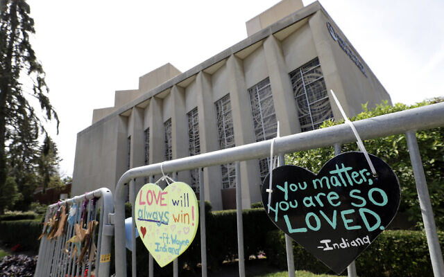 Signs hang on a fence surrounding the Tree of Life synagogue in Pittsburgh, on September 17, 2019. (AP Photo/Gene J. Puskar/File)