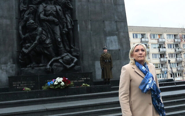 French far-right leader Marine Le Pen pays respects at the memorial to the heroes of the Warsaw Ghetto Uprising, in Warsaw, Poland, on Friday December 3, 2021. (AP Photo/Adam Jankowski)