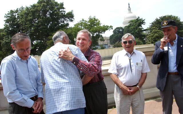 Edward Shames, center, hugs Ed McClung, center left, both members of the World War II Army Company E of the 506th Regiment of the 101st Airborne, with veterans Jack Foley, left, Joe Lesniewski, right, and Shifty Powers, far right, at the Library of Congress in Washington, on July 16, 2003. (AP Photo/Gerald Herbert, File)