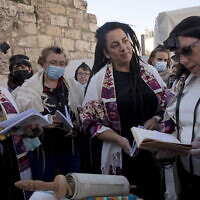 Members of Women of the Wall gather around a Torah scroll the group smuggled in for their Rosh Hodesh prayers marking the new month at the Western Wall, where women are forbidden from reading from the Torah, December 5, 2021. (AP Photo/Maya Alleruzzo)