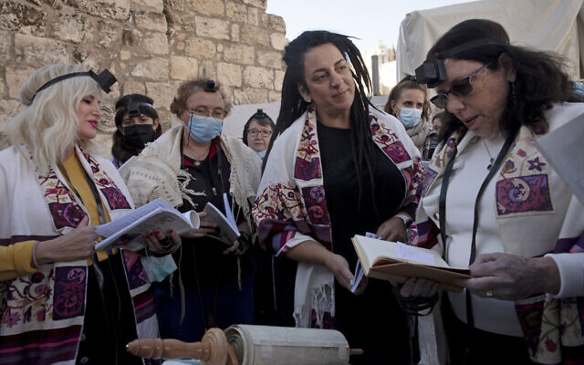 Members of Women of the Wall gather around a Torah scroll the group smuggled in for their Rosh Hodesh prayers marking the new month at the Western Wall, where women are forbidden from reading from the Torah, December 5, 2021. The Jewish women's group has waged a campaign for gender equality at the site for a long time. (AP Photo/Maya Alleruzzo)