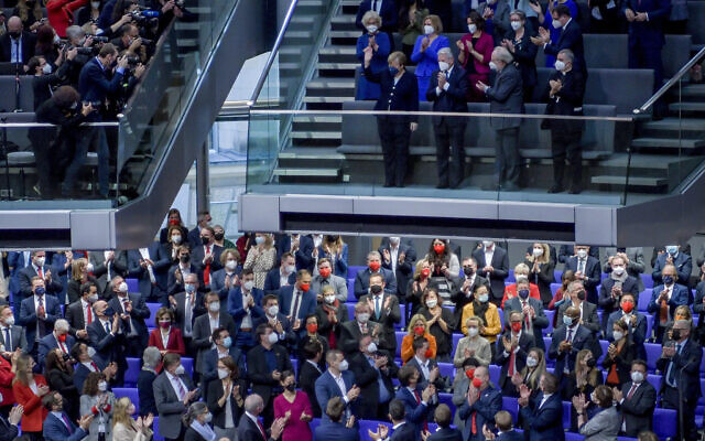 Lawmakers applaud outgoing German Chancellor Angela Merkel, center on top, in the German Parliament Bundestag in Berlin, Wednesday, Dec. 8, 2021. (AP Photo/Stefanie Loos)