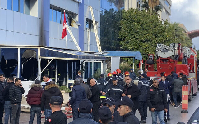 Firemen stand outside the Ennahda party headquarters after a fire broke out at Tunisia's Ennahdha, Tunisia's moderate Islamist party, December 9, 2021, in Tunis. (AP Photo/Francesca Ebel)