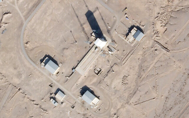 A support vehicle stands parked alongside a massive white gantry that typically houses a rocket on the launch pad as activity is seen at the Imam Khomeini Spaceport in Semnan province, Iran, December 11, 2021. (Satellite photograph by Planet Labs Inc. via AP)