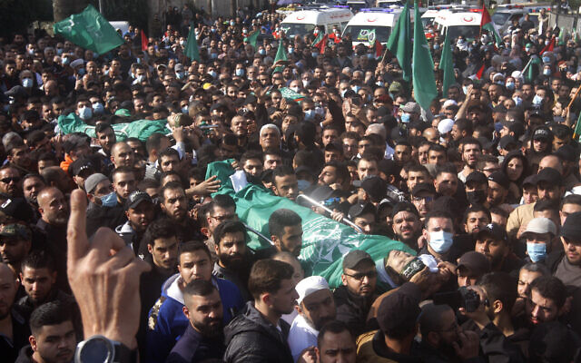 Palestinian mourners carry the bodies of two members of Hamas who were killed after gunfire erupted last Sunday during a Hamas-organized funeral in a Palestinian refugee camp, during their funeral procession in the southern port city of Sidon, Lebanon, on December 14, 2021. (AP Photo/Mohammed Zaatari)