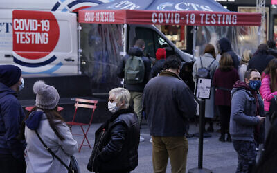 People wait in line at a COVID-19 testing site in Times Square, New York, Dec. 13, 2021 (AP Photo/Seth Wenig, File)