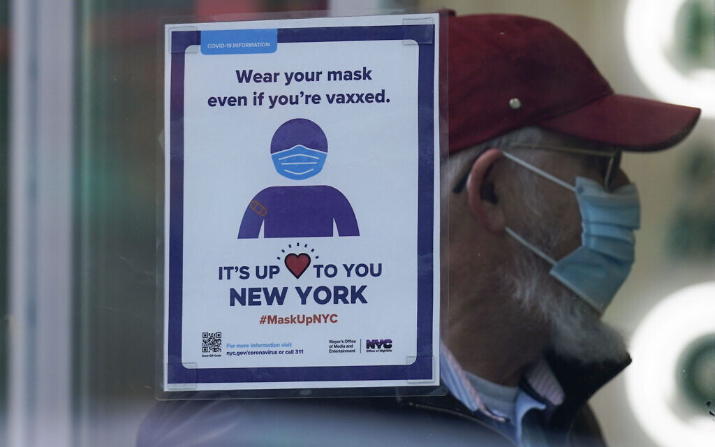 A sign reminds customers that masks are required in their store in New York, December 13, 2021. (AP Photo/Seth Wenig, File)