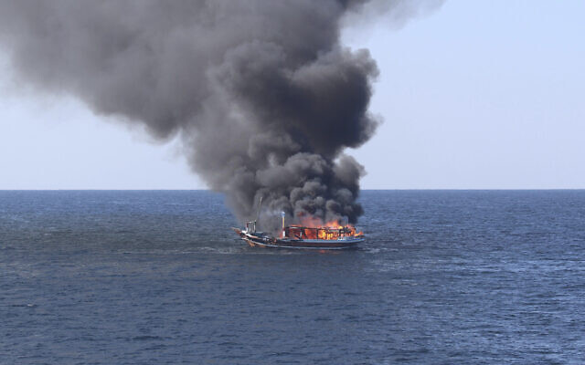 In this handout photograph from the US Navy, a traditional dhow sailing vessel suspected of smuggling drugs burns in the Gulf of Oman on Wednesday, Dec. 15, 2021. (US Navy via AP)