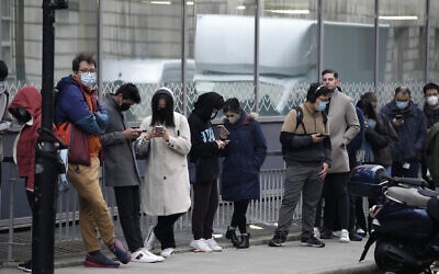 People queue up to get COVID-19 booster injections outside a vaccination center in a UCL (University College London) building, in London, on Friday, December 17, 2021. (AP Photo/Matt Dunham)