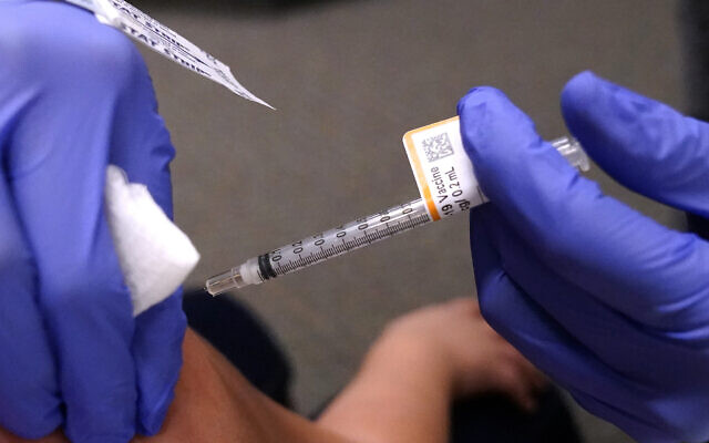 An eight-year-old child receives a second dose of the Pfizer COVID-19 vaccine at Northwest Community Church in Chicago, December 11, 2021. (AP Photo/Nam Y. Huh)