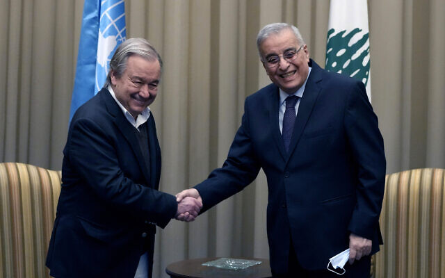 Lebanese Foreign Minister Abdallah Bouhabib, right, shakes hand with United Nations Secretary-General Antonio Guterres, upon his arrival at the Rafik Hariri International Airport in Beirut, Lebanon, December 19, 2021. (AP Photo/Hassan Ammar)