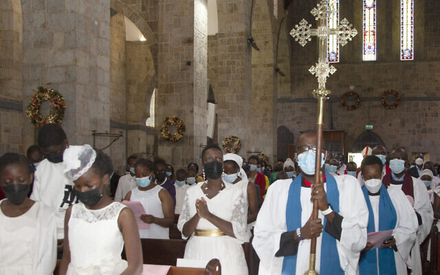 Churchgoers wear face masks to curb the spread of COVID-19 as they attend a Mass at All Saints Cathedral in Nairobi, Kenya, Dec. 24, 2021. (AP Photo/Sayyid Abdul Azim)