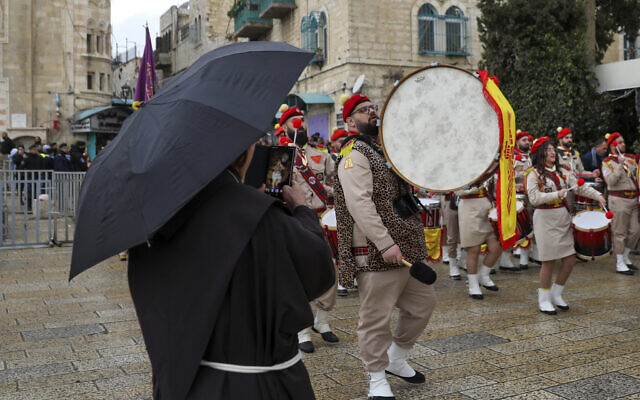 Palestinian scout bands parade through Manger Square at the Church of the Nativity during Christmas celebrations in Bethlehem, Dec. 24, 2021 (AP Photo/Mahmoud Illean)
