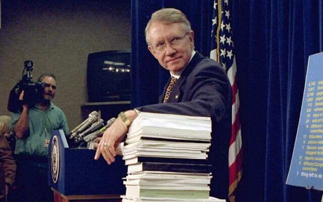 Sen. Harry Reid, Democrat-Nevada, leans on a stack of documents pertaining to campaign finance reform during a Capitol Hill news conference on Dec. 3, 1996. (Dennis Cook/AP)