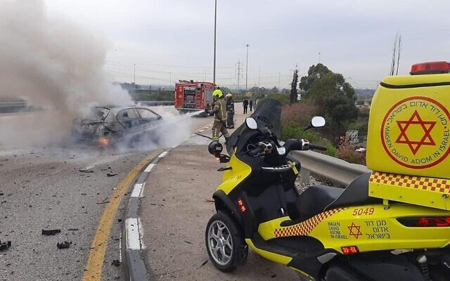 Firefighters work to extinguish a car on fire on Route 5 near Kafr Qasim on December 28, 2021. (Magen David Adom)
