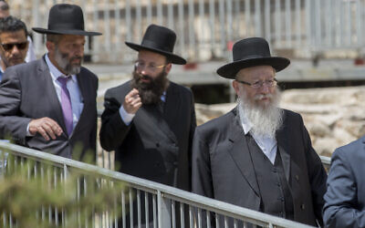 Then-minister of health Yaakov Litzman of the United Torah Judaism party (right) and then-interior minister Aryeh Deri of Shas (left) flank the Rabbi of the Western Wall, Shmuel Rabinovitch, during a visit to the pluralistic prayer pavilion at the Western Wall in Jerusalem's Old City on May 30, 2016. (Yonatan Sindel/Flash90)
