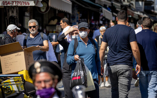 People wearing face masks shop at the Mahane Yehuda Market in Jerusalem, on October 5, 2021. (Yonatan Sindel/Flash90)