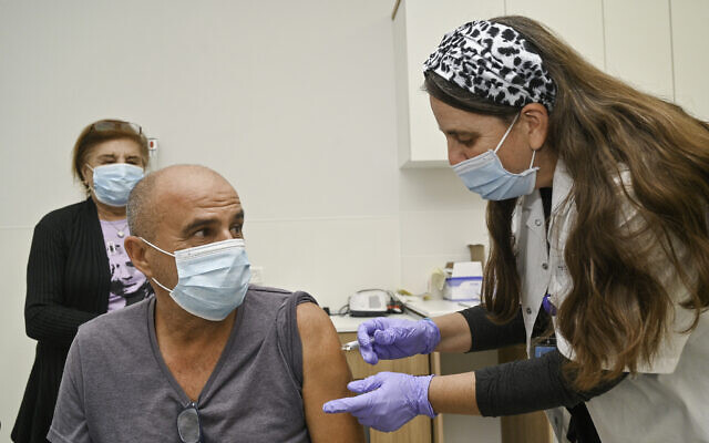 An Israeli man receives a dose of the COVID-19 vaccine in Katzrin, November 16, 2021. (Michael Giladi/Flash90)