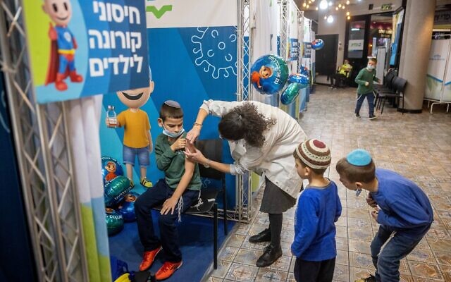 Children aged 5-11 receive their first dose of a COVID-19 vaccine, at Clallit vaccination center in Jerusalem on November 25, 2021. (Yonatan Sindel/Flash90)