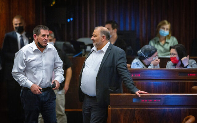 Ra'am leader Mansour Abbas and Yoav Segalovitz, deputy public security minister, discuss the Electricity Law during a plenum session in the Knesset on December 6, 2021. (Olivier Fitoussi/FLASH90)