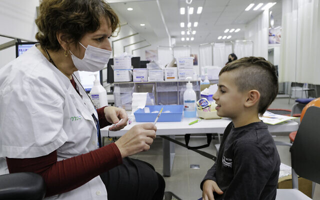 Children aged 5-11 receive a dose of COVID-19 vaccine, at Clalit vaccination center in Katzrin, Golan Heights, on December 16, 2021. (Michael Giladi/Flash90)