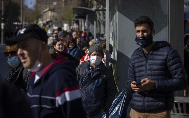 People walk on Jaffa Street in Jerusalem, some with face masks, December 21, 2021. (Olivier Fitoussi/Flash90)