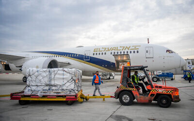 Airport workers unload packages of Pfizer’s COVID-fighting Paxlovid pill at Ben Gurion International Airport on December 30, 2021. (Avshalom Sassoni/Flash90)