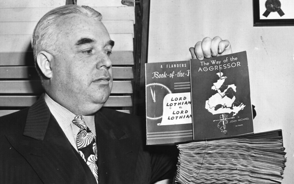 Boston Police Commissioner Joseph Timilty displays two books distributed by the Christian Front, which were declared Nazi propaganda and banned from sale in the city on January 5, 1942. (Photo Credit: Boston Herald- Traveler Photo Morgue/ Boston Public Library/ Courtesy of Harvard University Press)