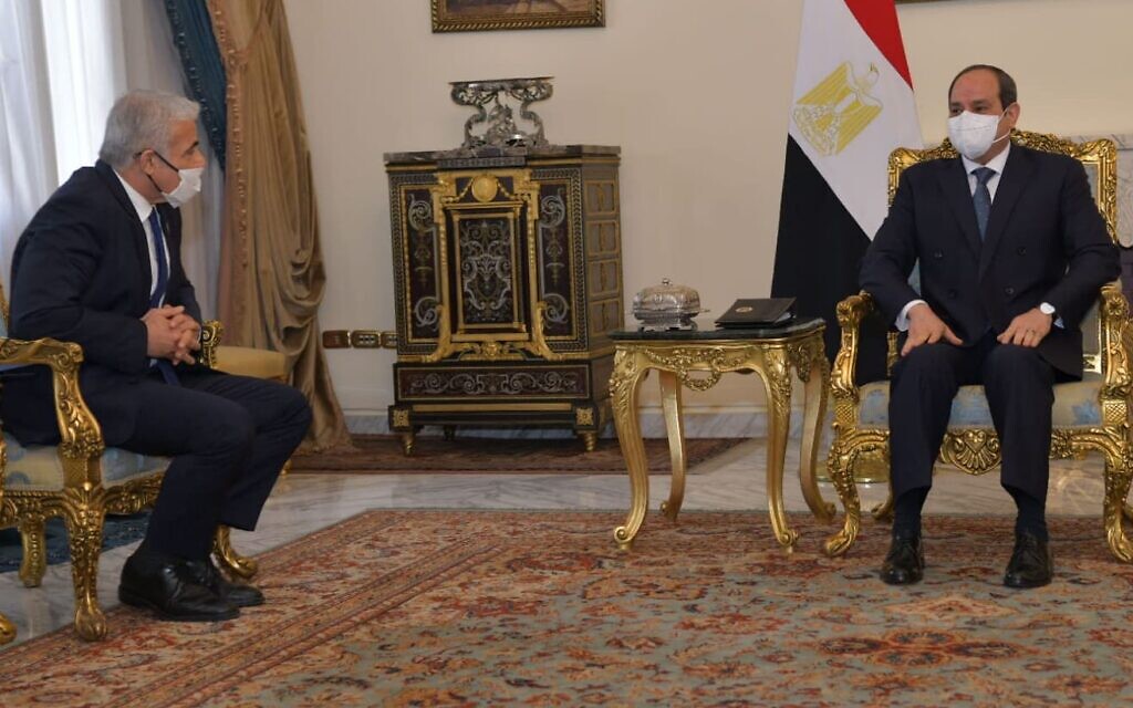 Foreign Minister Yair Lapid sits with Egyptian President Abdel-Fattah el-Sissi in Cairo, December 9, 2021 (Shlomi Amsalem/GPO)