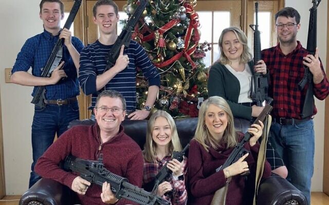 Congressman Thomas Massie poses with six members of his family holding guns with the words 'Merry Christmas! ps. Santa, please bring ammo' (Twitter)