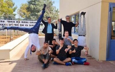 Ambassador Dan Oryan (left) joins Emek Hefer Regional Council head Galit Shaul (second from left), singer Mosh Ben Ari (second from right), Israeli capoeira champion Mickey Hayat (right), and children with special needs from the Benjamin Rothman Shvilei Ha'Emek School in a photo for the Foreign Minstry's Upside Down exhibition. (Courtesy)