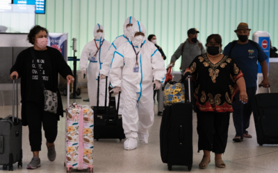 Air China flight crew members in hazmat suits walk through the arrivals area at Los Angeles International Airport in Los Angeles, Nov. 30, 2021 (AP Photo/Jae C. Hong)
