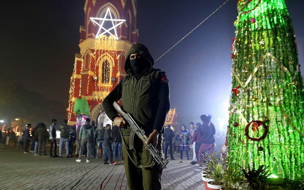A police officer stands guard at St. Anthony's Church as Christians arrive to attend midnight Christmas mass, in Lahore, Pakistan, December 24, 2021. (AP Photo/K.M. Chaudary)