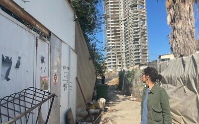 Ronit Aldouby looks at her Givat Amal home, with luxury towers overlooking, on November 23, 2021. (Carrie Keller-Lynn/Times of Israel)