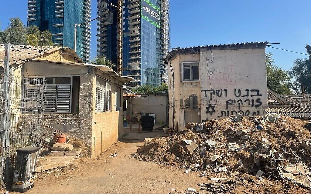 Evacuated Givat Amal homes, Park Bavli towers looming above them, on November 23, 2021. (Carrie Keller-Lynn/Times of Israel)