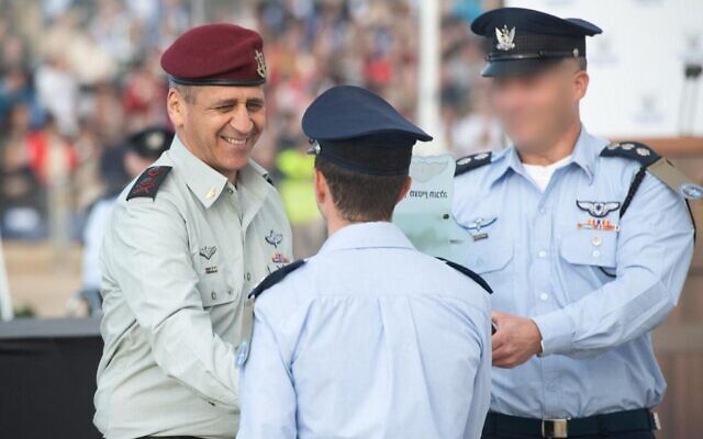 IDF chief Aviv Kohavi shakes hands with a graduates during a ceremony marking the end of the Israeli Air Force's pilot course, at the Hatzerim airbase in southern Israel, on December 22, 2021. (Israel Defense Forces)