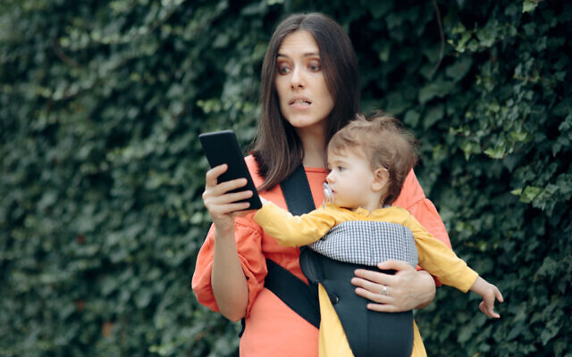 Stressed mother holding smartphone (iStock)