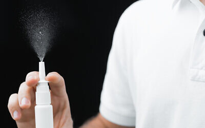 Illustrative: A man checks a nasal spray bottle. (Malikov Aleksandr; iStock by Getty Images)