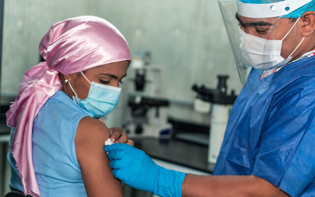 A woman with cancer receives a coronavirus vaccine (Hector Pertuz via iStock by Getty Images)