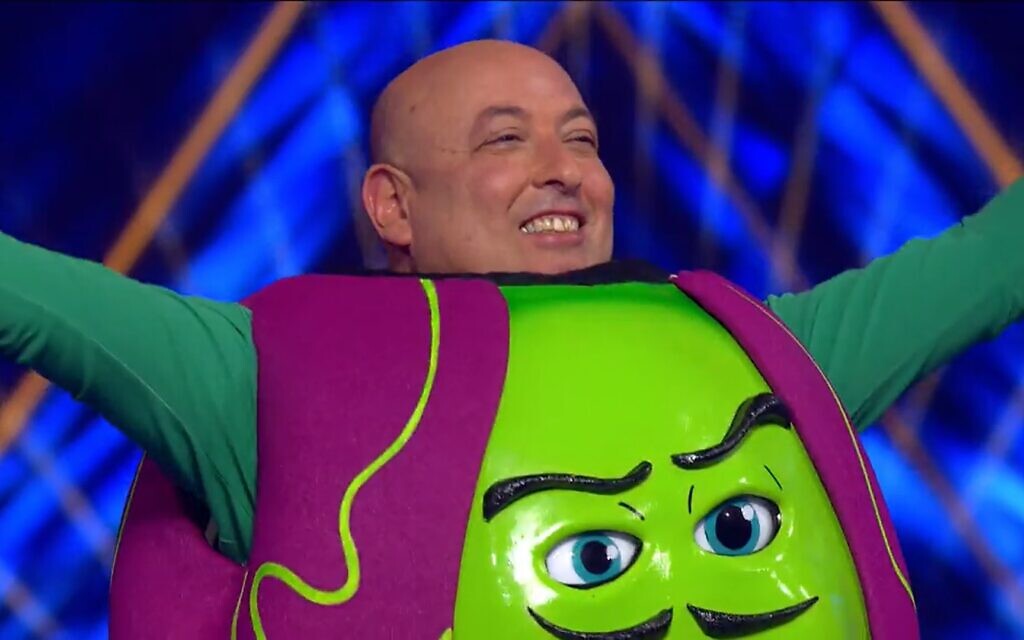 Former Health Ministry deputy director Itamar Grotto is revealed as the "Pea" on Israel's "Masked Singer" on October 25, 2021. (Keshet 12)