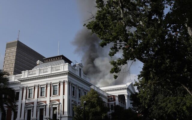 Smoke billows from the roof of a building at the South African Parliament precinct in Cape Town on January 2, 2022, during a fire incident. (Marco Longari / AFP)