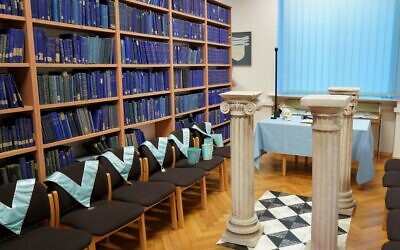 Masonic collars are seen next to book shelves at the Poznan University Library, housing a historic archive of Freemasonry in Europe amassed by the Nazis, in Poznan, western Poland on December 22, 2021. (JANEK SKARZYNSKI / AFP)