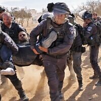 Israeli police detain a man as Bedouins protest in the Negev Desert against a forestation project by the Jewish National Fund (JNF), on January 12, 2022. (AHMAD GHARABLI / AFP)