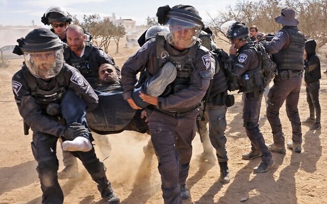 Israeli police detain a man as Bedouins protest in the Negev Desert against a forestation project by the Jewish National Fund (JNF), on January 12, 2022. (AHMAD GHARABLI / AFP)