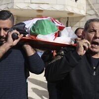 Palestinian relatives carry the body of Omar As'ad, 80, at his funeral; As'ad was found dead after being detained and handcuffed during an Israeli raid, in Jiljilya village in the West Bank, on January 13, 2022. ((JAAFAR ASHTIYEH / AFP)