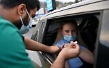 A woman receives a COVID-19 vaccine at a drive-thru NHS vaccination center in Blackburn, north-west England, on January 17, 2022, as the Omicron coronavirus variant spreads in the country. (Paul Ellis/AFP)