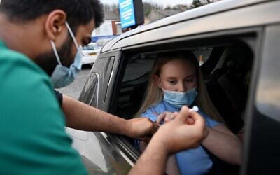 A woman receives a COVID-19 vaccine at a drive-thru NHS vaccination center in Blackburn, north-west England, on January 17, 2022, as the Omicron coronavirus variant spreads in the country. (Paul Ellis/AFP)